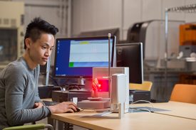 student using computer and laser